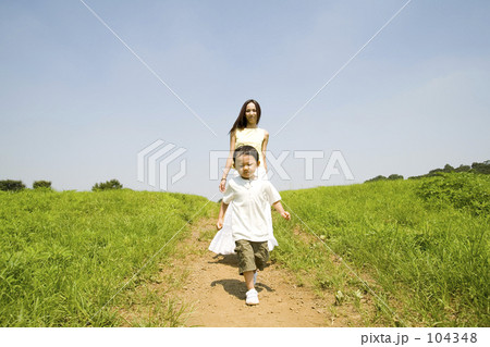 女性 丘 歩く ロングスカートの写真素材