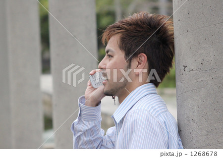 髭 茶髪 携帯電話 ワイシャツの写真素材