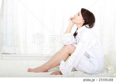 女性 座る 横向き ワイシャツ 美人の写真素材