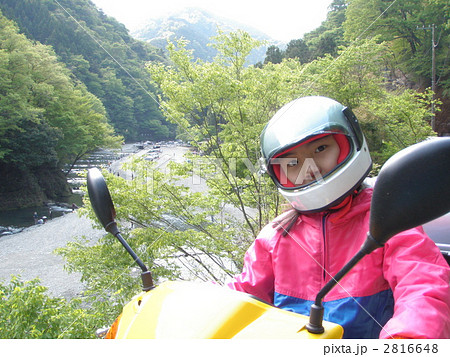 バイク スクーター 黄色 晴れ かわいい 女の子 フルフェイスの写真素材