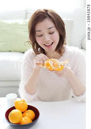 女性 みかん 食べる 果物の写真素材