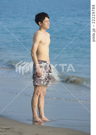 男性 水着姿 佇む ビーチの写真素材
