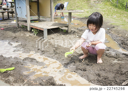 泥んこ遊びをする女の子の写真素材