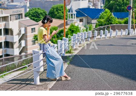 女性 一人旅 道端 座るの写真素材