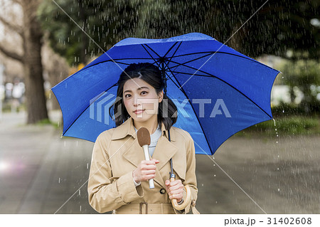 女性 レポーター リポーター 雨の写真素材