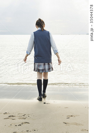 女子高生 後ろ姿 制服 波の写真素材