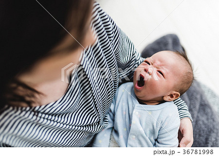 あくび 眠い 赤ちゃん 抱っこの写真素材