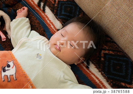 女の子 赤ちゃん お昼寝 大の字の写真素材