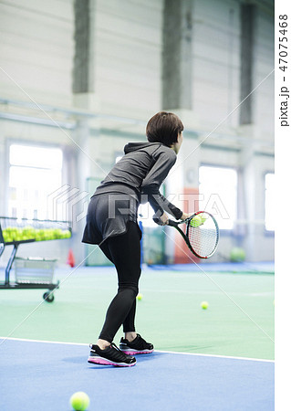 人物 女性 後姿 テニス サーブの写真素材