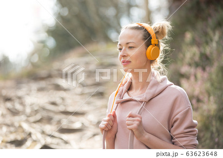 女性 女の子 ヘッドフォン パーカー 音楽の写真素材