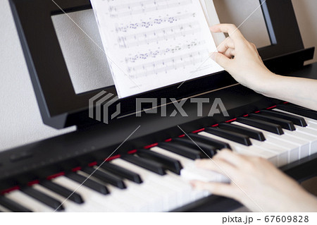 電子ピアノ 手 両手 鍵盤 楽譜 ピアノの写真素材