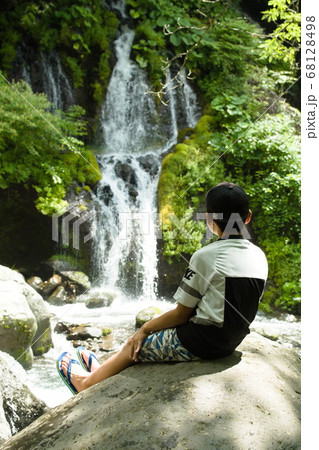 男性 後姿 座る 河川の写真素材
