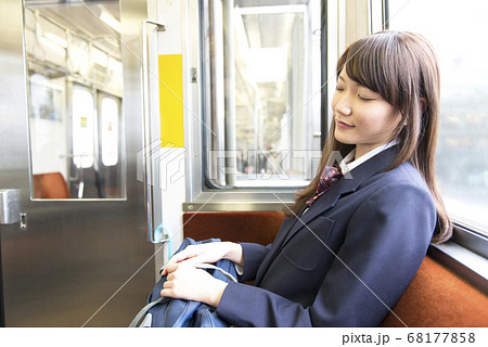 女子高生 居眠り 電車 通学の写真素材