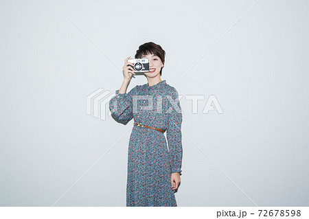 女性 覗く 構える カメラの写真素材