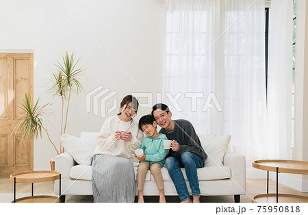 スマイル 座る 正面 ソファーの写真素材