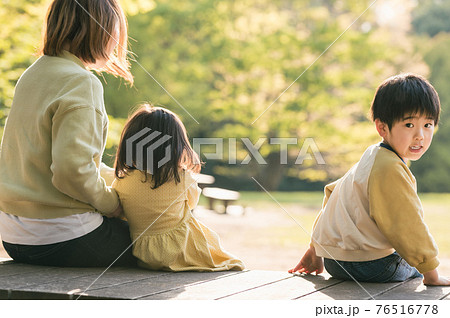 女性 座る 後姿 ベンチの写真素材