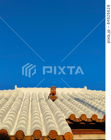 沖縄の家の屋根の上のシーサーの写真素材