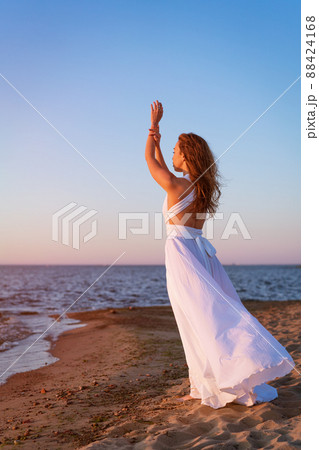 女の子 白いワンピース 海 風の写真素材